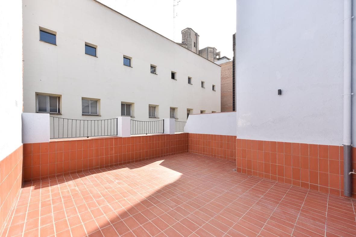 La terraza rehabilitada, con el solado y el zócalo cerámicos nuevos y las barandillas de hierro restauradas