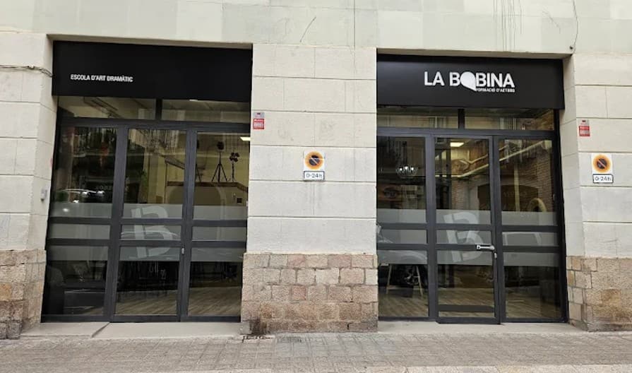 Fachada del local con los dos accesos rotulados, Escola d'Art Dramàtic y La Bobina, en la planta baja del edificio