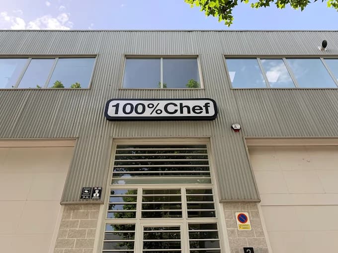 Fachada de la nave de 100% Chef, con el rótulo sobre la puerta de entrada