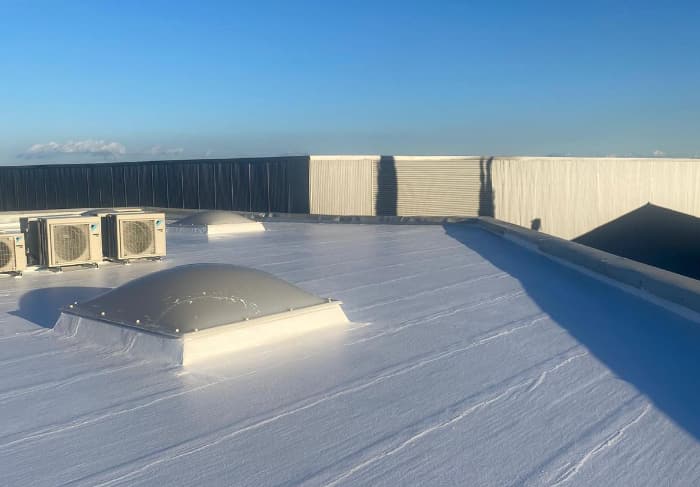 Detalle de una claraboya nueva y de las unidades exteriores de climatización sobre la cubierta impermeabilizada