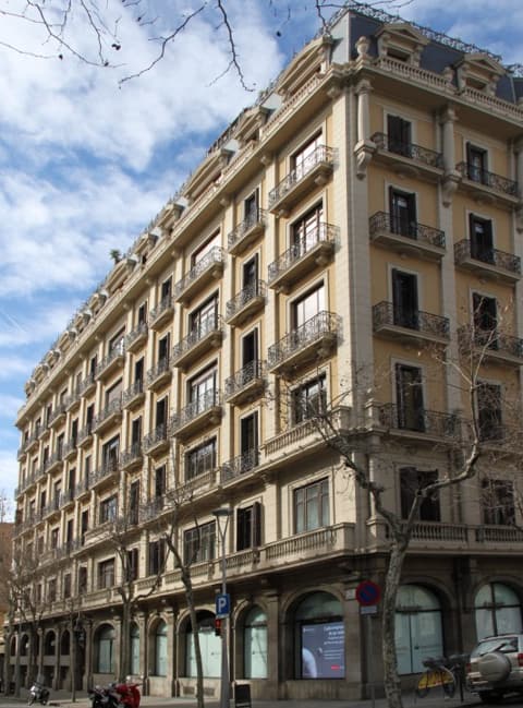 El edificio en escorzo desde la calle lateral, con los arcos de la planta baja