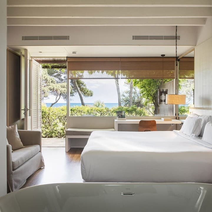Habitación con bañera exenta y ventanal hacia el pinar y el mar