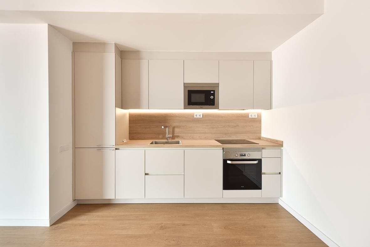 Frente de cocina en blanco con encimera y salpicadero de roble