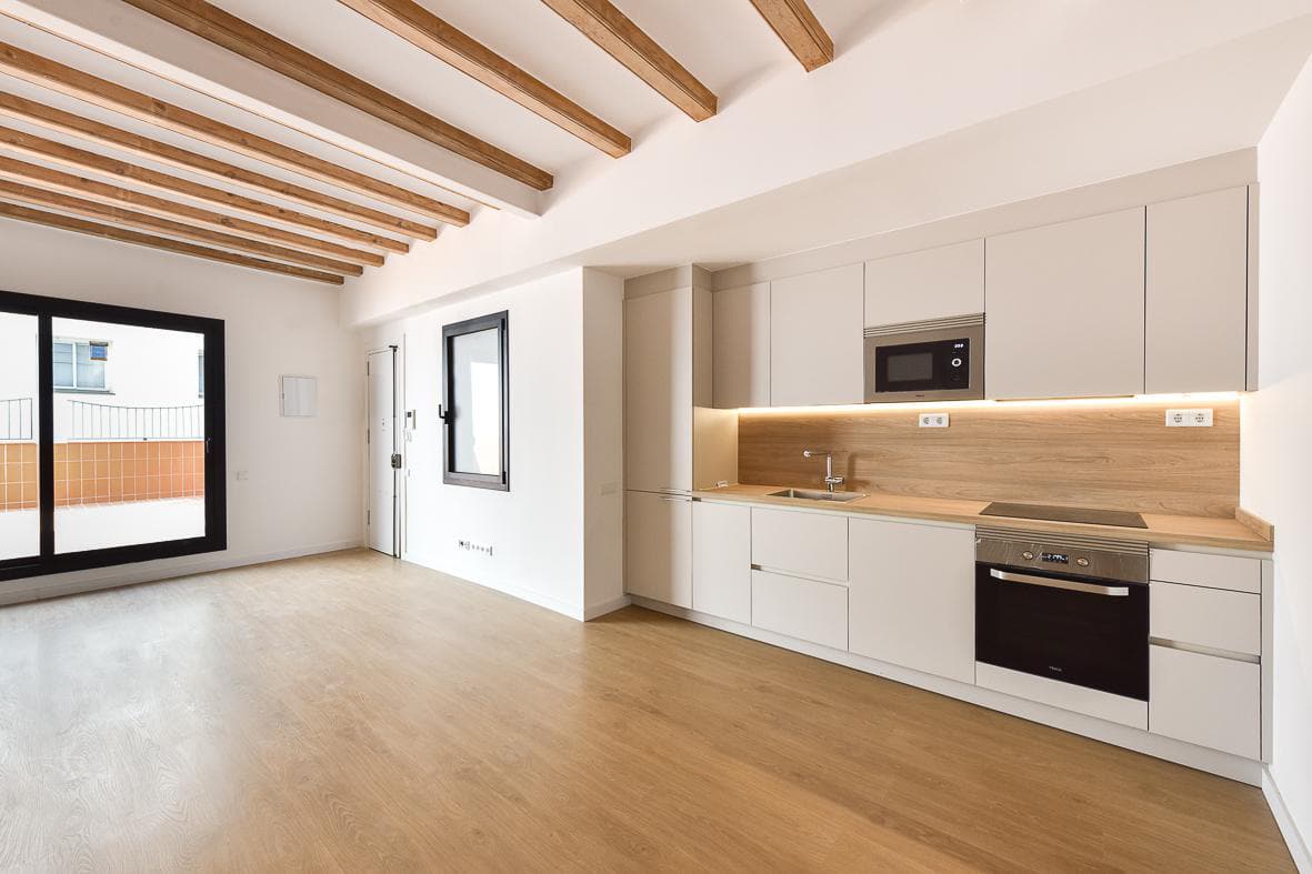 Salón-cocina con vigas vistas y salida a la terraza