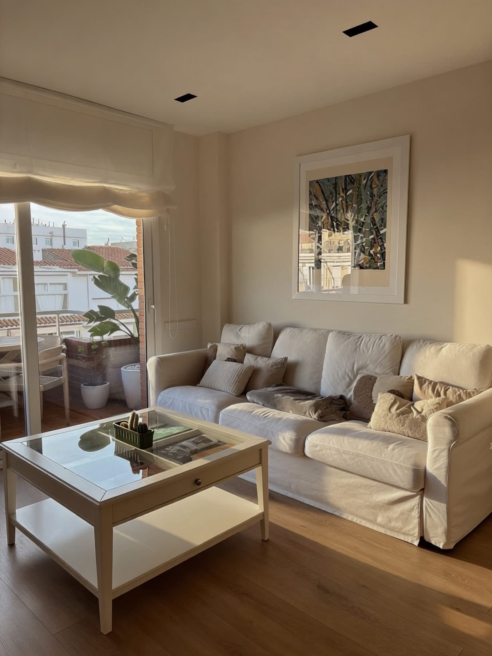 Salón con sofá y salida a la terraza a través de la balconera