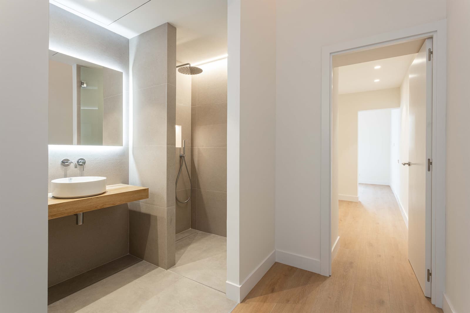 Baño y paso al distribuidor, con la ducha revestida de gres de aspecto piedra