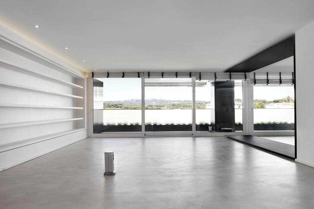 Salón con estantería corrida y ventanal corredero hacia la terraza