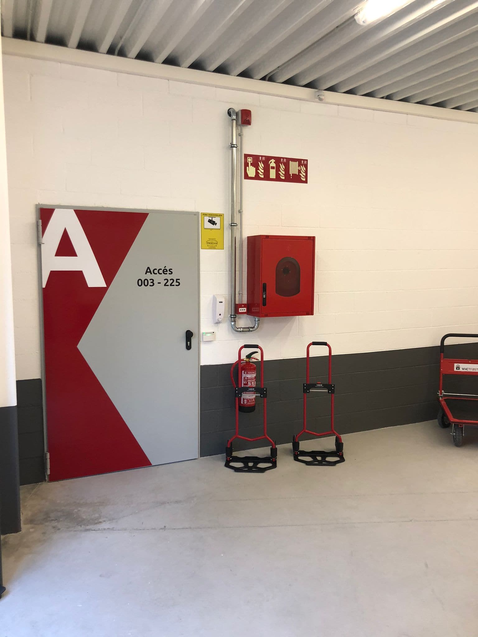 Puerta cortafuegos del acceso A, con la boca de incendio equipada, el extintor y la señalización fotoluminiscente