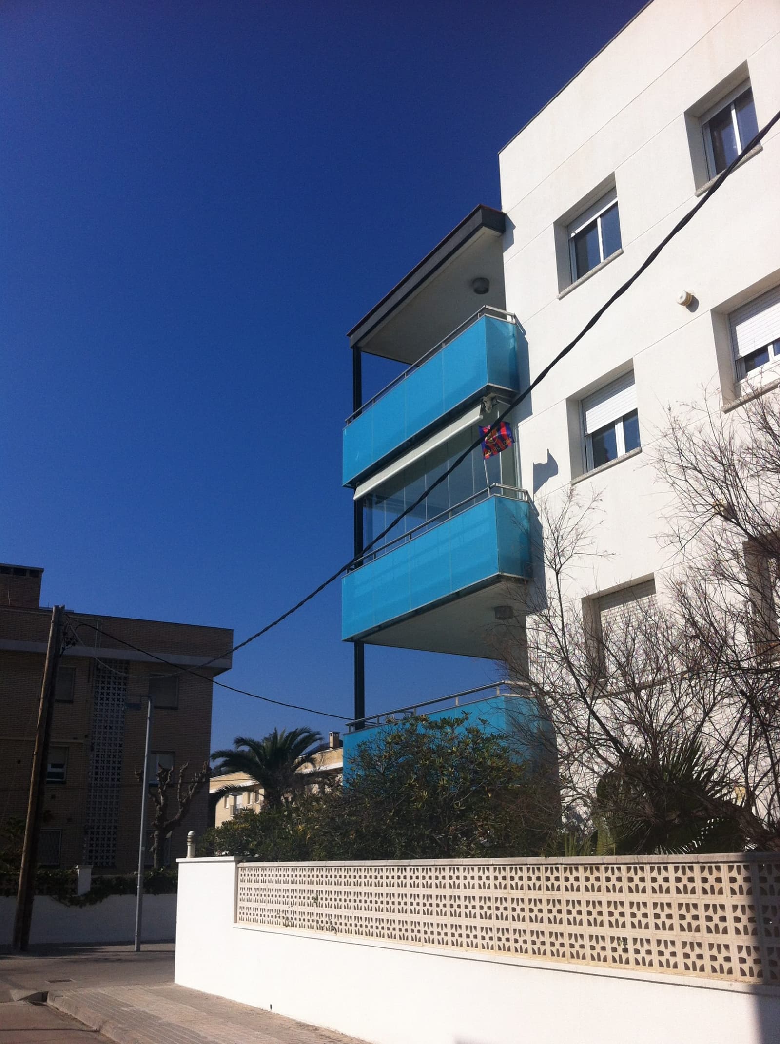 Contrapicado de los balcones en voladizo, con las barandillas metálicas recuperadas recortadas contra el cielo