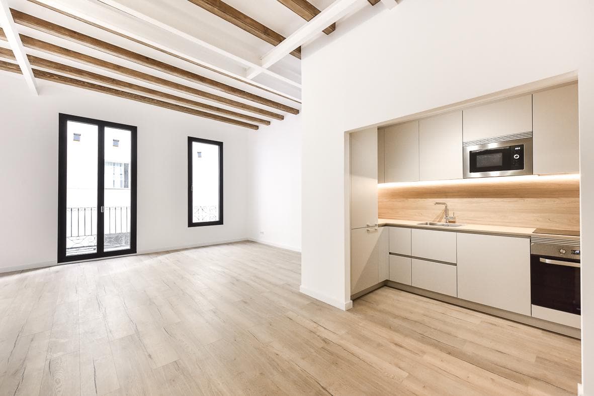 Home renovated by CRUGA Rehabilita with the original timber beams restored and a new kitchen