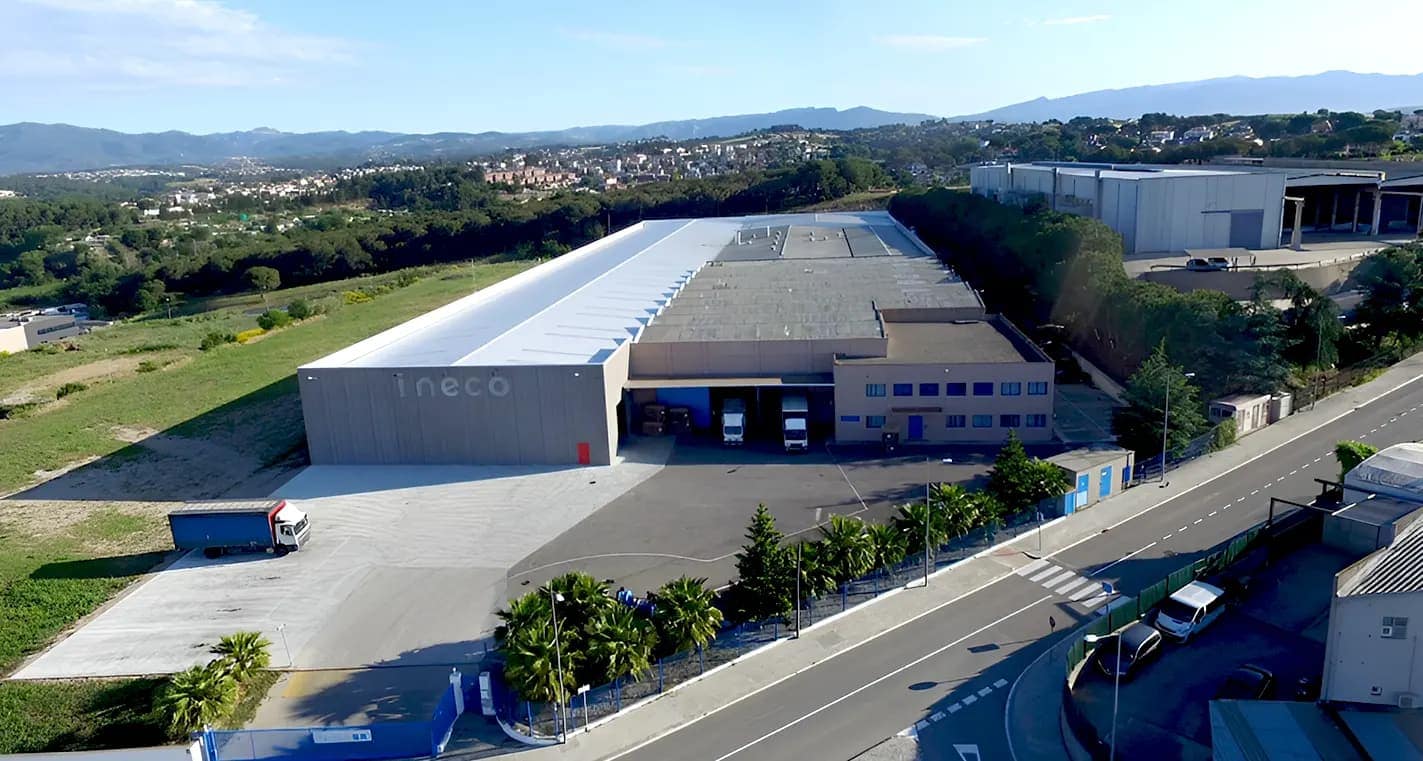 Vista aérea de la planta de INECO, con el rótulo en la fachada de la nave y los muelles de carga