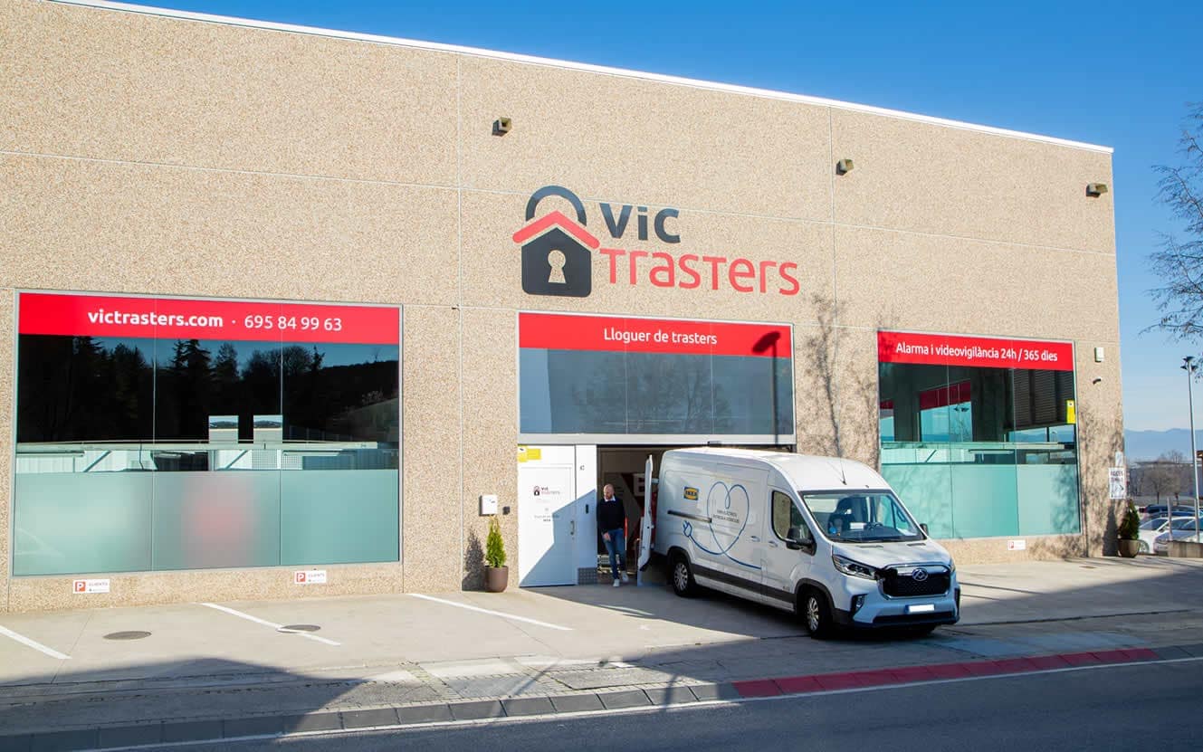 Fachada de Vic Trasters, con el rótulo sobre la entrada y una furgoneta de reparto en la puerta